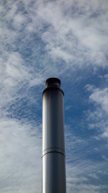 Bulutlu gökyüzüne karşı sanayi bacası.