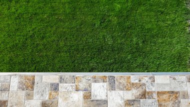 Yeşillik çimenlik, taş döşeli yürüyüş yolu..