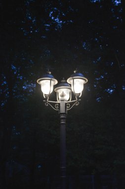 Eskimiş sokak lambası gece parlıyor.