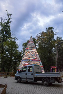Yakınlarda park etmiş bir kamyon olan sanat kurulumu ağacı..