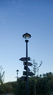 Açık mavi gökyüzüne karşı sokak lambası ve tabelalar