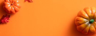 Balkabağı, sonbahar yaprakları ve fotokopi alanı ile turuncu masa zemininde yaratıcı Cadılar Bayramı tasarım konsepti