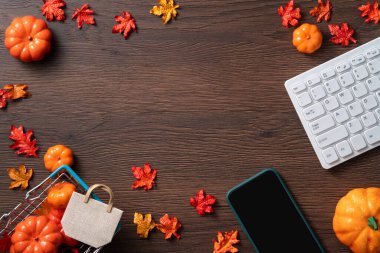 Ahşap masa üzerinde alışveriş arabasıyla sonbahar çevrimiçi tasarım konsepti.