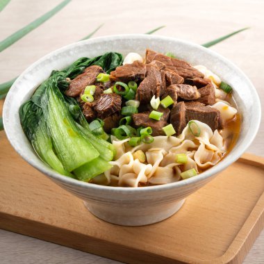 Erişte çorbası. Tayvan 'ın ünlü yemekleri dilimlenmiş kırmızı et ve sebzeler ahşap masa arkasında bir kasede..