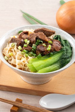 Erişte çorbası. Tayvan 'ın ünlü yemekleri dilimlenmiş kırmızı et ve sebzeler ahşap masa arkasında bir kasede..