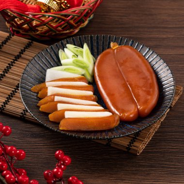 Delicious fresh mullet roe with white radish slices and garlic sprout for Chinese lunar new year gift basket box, holiday celebration.