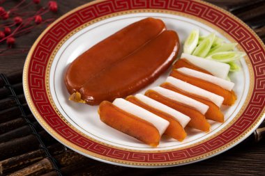 Delicious fresh mullet roe with white radish slices and garlic sprout for Chinese lunar new year gift basket box, holiday celebration.