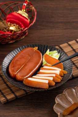 Delicious fresh mullet roe with white radish slices and garlic sprout for Chinese lunar new year gift basket box, holiday celebration.