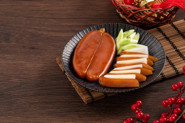 Delicious fresh mullet roe with white radish slices and garlic sprout for Chinese lunar new year gift basket box, holiday celebration.