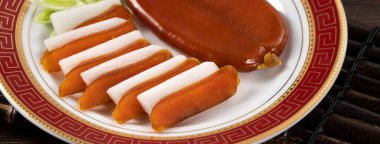 Delicious fresh mullet roe with white radish slices and garlic sprout for Chinese lunar new year gift basket box, holiday celebration.