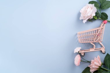 Sevgililer günü ve Anneler Günü hediye tasarım konsepti pembe gül, karanfil çiçeği ve mavi masa arkasında paketlenmiş hediye kutusu..