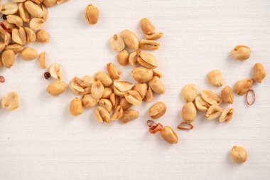 Baharatlı fıstık çekirdeği beyaz masa arkasına dökülüyor..