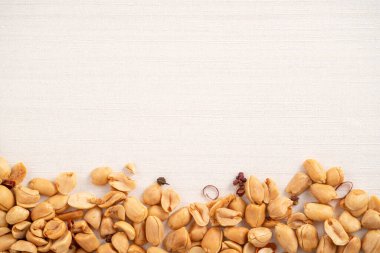 Baharatlı fıstık çekirdeği beyaz masa arkasına dökülüyor..