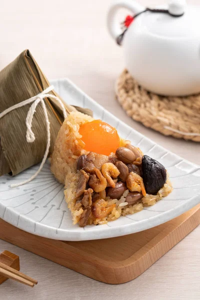 Zongzi, Çin geleneksel Ejderha Tekne Festivali (Duanwu Festivali) için ahşap masa arkasında pirinç köftesi..