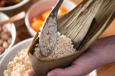 Zongzi yemeği yapmak - Duanwu Ejder Teknesi Festivali için evde Çin pirinçli börek hazırlamak ve paketlemek, yaşam tarzı.