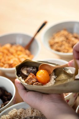 Zongzi yemeği yapmak - Duanwu Ejder Teknesi Festivali için evde Çin pirinçli börek hazırlamak ve paketlemek, yaşam tarzı.