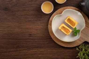 Lezzetli Tayvan usulü ünlü ananaslı pasta tatlı ahşap masa arkasında sıcak çay ile birlikte..