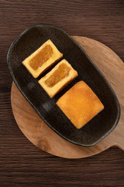 Lezzetli Tayvan usulü ünlü ananaslı pasta tatlı ahşap masa arkasında sıcak çay ile birlikte..