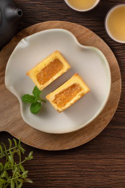 Lezzetli Tayvan usulü ünlü ananaslı pasta tatlı ahşap masa arkasında sıcak çay ile birlikte..