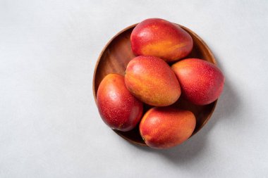 Mango arka plan tasarımı konsepti. Gri masa yaprakları ile kesilmiş taze mango desenli üst manzara.