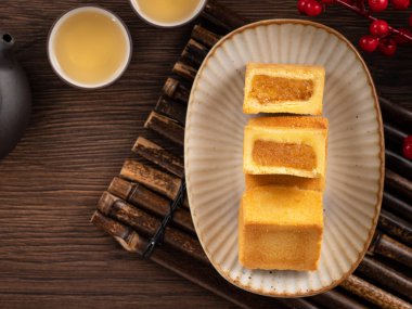 Lezzetli Tayvan usulü ünlü ananaslı pasta tatlı ahşap masa arkasında sıcak çay ile birlikte..