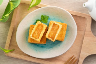 Lezzetli Tayvan usulü ünlü ananaslı pasta tatlı ahşap masa arkasında sıcak çay ile birlikte..