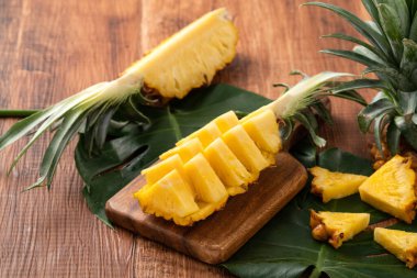 Taze kesilmiş ananasları koyu ahşap masa arkasındaki tepside kapat..