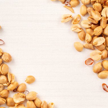 Baharatlı fıstık çekirdeği beyaz masa arkasına dökülüyor..