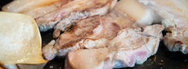 Jeju Kore restoranında kızarmış siyah domuz eti, demir tabakta taze Kore mutfağı marul, kimchi, banchan ve sos, yaşam tarzı.