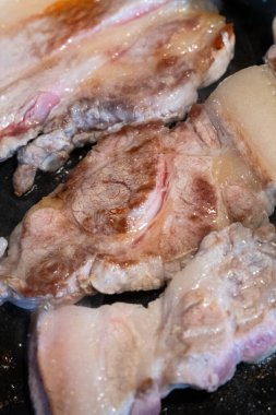 Jeju Kore restoranında kızarmış siyah domuz eti, demir tabakta taze Kore mutfağı marul, kimchi, banchan ve sos, yaşam tarzı.