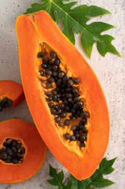 Tropikal meyve tasarımı kavramı için Papaya 'yı gri masa arkaplanından kes, üst görünüm kopyalama alanı.