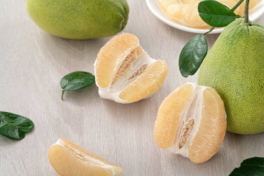 Güz ortası meyve festivali için ahşap masa arkasındaki soyulmuş taze pomelo 'yu kapat..