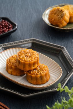 Delicious Cantonese moon cake for Mid-Autumn Festival food mooncake on blue table background for afternoon tea, holiday celebration serving.