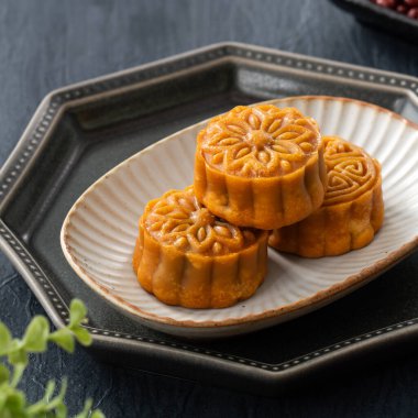 Delicious Cantonese moon cake for Mid-Autumn Festival food mooncake on blue table background for afternoon tea, holiday celebration serving.