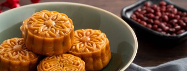 Delicious Cantonese moon cake for Mid-Autumn Festival food mooncake on wooden table background for afternoon tea, holiday celebration serving.
