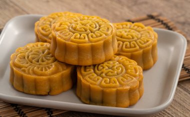 Delicious Cantonese moon cake for Mid-Autumn Festival food mooncake on wooden table background for afternoon tea, holiday celebration serving.