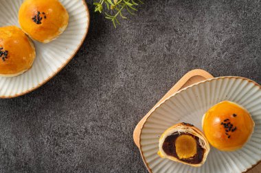 Ay pastası sarısı pastası, sonbahar ortası festivali için ay çöreği gri masa arkasında tatil.