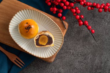 Ay pastası sarısı pastası, sonbahar ortası festivali için ay çöreği gri masa arkasında tatil.