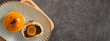 Ay pastası sarısı pastası, sonbahar ortası festivali için ay çöreği gri masa arkasında tatil.