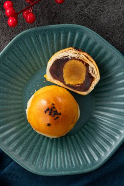 Ay pastası sarısı pastası, sonbahar ortası festivali için ay çöreği gri masa arkasında tatil.