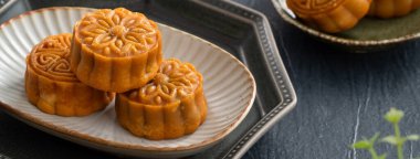 Delicious Cantonese moon cake for Mid-Autumn Festival food mooncake on blue table background for afternoon tea, holiday celebration serving.