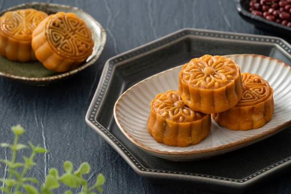 Delicious Cantonese moon cake for Mid-Autumn Festival food mooncake on blue table background for afternoon tea, holiday celebration serving.