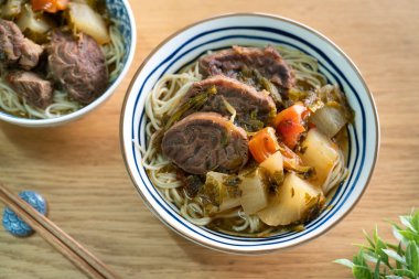 Erişte çorbası. Tayvan 'ın ünlü yemekleri dilimlenmiş kırmızı et ve sebzeler ahşap masa arkasında bir kasede..