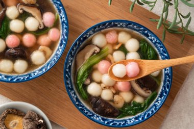 Ev yapımı kırmızı-beyaz tangyuan, tang yuan, glutinous pirinç köftesi ve beyaz arka planda lezzetli bir çorba..