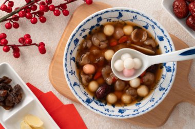 Küçük ev yapımı kırmızı ve beyaz tangyuan, tang yuan, pirinç köftesi, tatlı şurup çorbası ve kış gündönümü festivali için kurutulmuş longan posası..