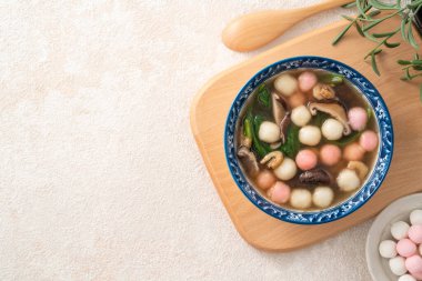Ev yapımı kırmızı-beyaz tangyuan, tang yuan, glutinous pirinç köftesi ve beyaz arka planda lezzetli bir çorba..