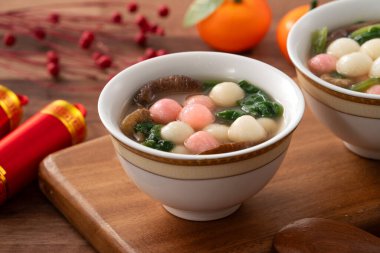 Kırmızı ve beyaz tangyuan, tang yuan, dolgun pirinç köfteleri ve ahşap masa üstünde lezzetli bir çorba yemek ay festivali için..