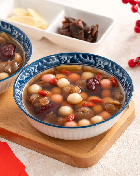 stock image Little homemade red and white tangyuan, tang yuan, rice dumpling balls, with sweet syrup soup and dried longan pulp for Winter solstice festival.