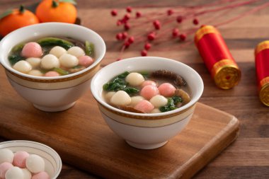 Kırmızı ve beyaz tangyuan, tang yuan, dolgun pirinç köfteleri ve ahşap masa üstünde lezzetli bir çorba yemek ay festivali için..
