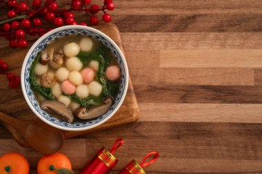 Kırmızı ve beyaz tangyuan, tang yuan, dolgun pirinç köfteleri ve ahşap masa üstünde lezzetli bir çorba yemek ay festivali için..